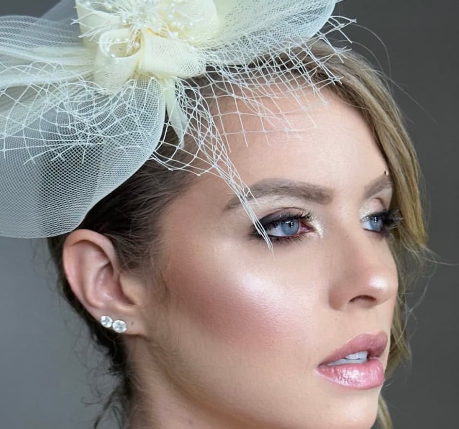 Close-up de beleza com fascinator e maquiagem elegante